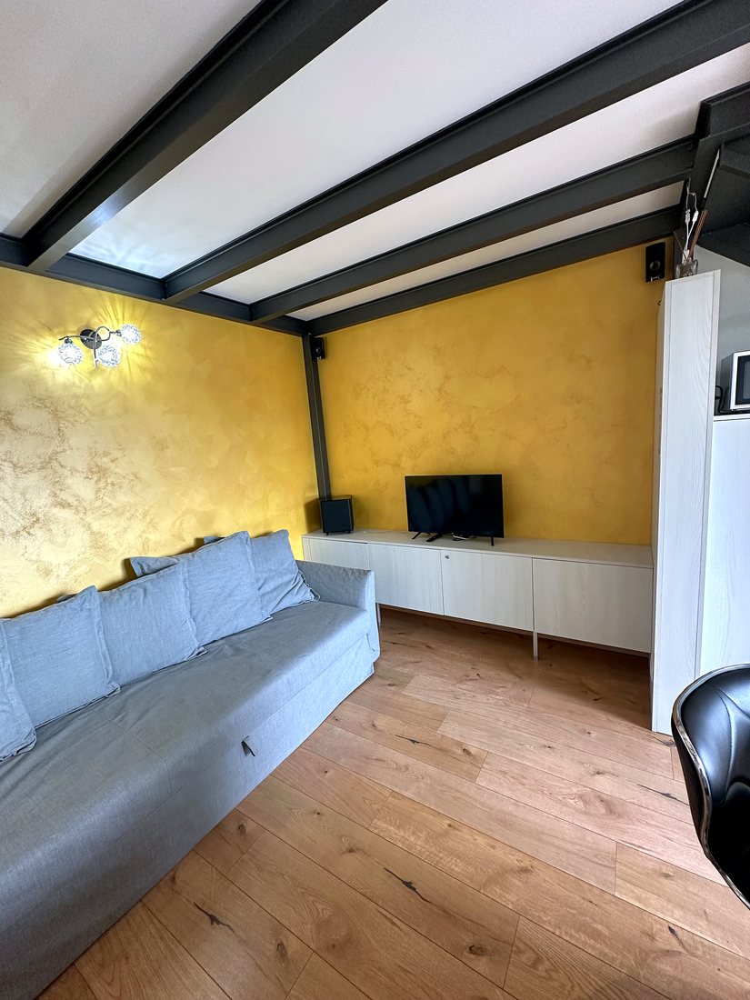Divano davanti alla parete color ocra del soggiorno
