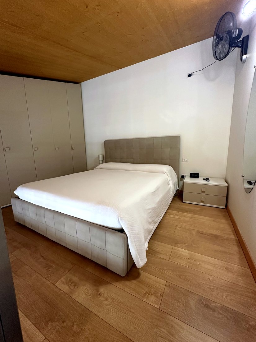 Camera da letto matrimoniale sotto il soffitto in legno