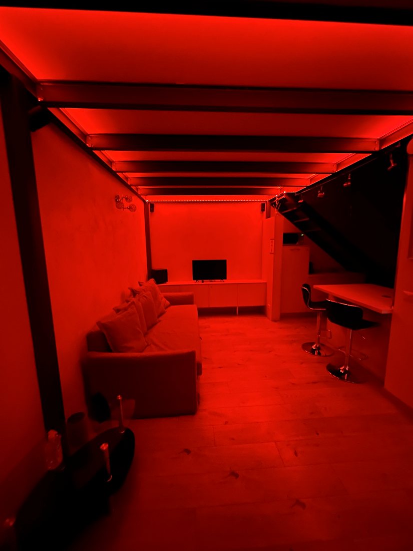 Il loft illuminato di rosso dalle luci LED a soffitto