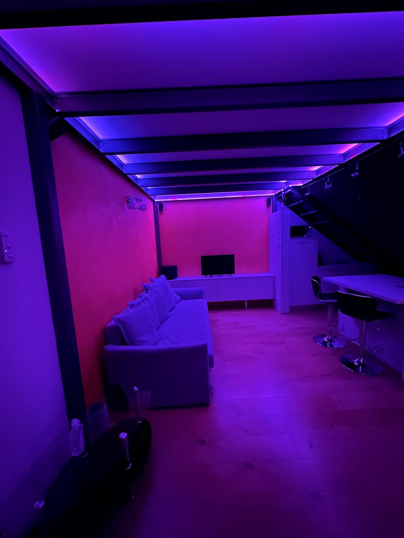 Il loft illuminato di viola dalle luci LED a soffitto