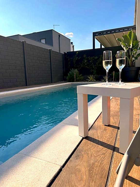 Due calici su un tavolino bianco a bordo della piscina privata