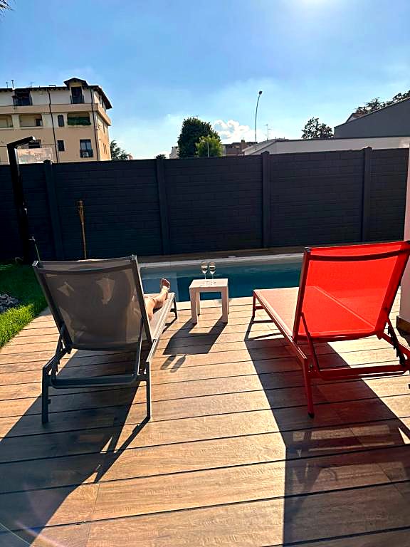 Lettini prendisole sul patio in legno accanto alla piscina