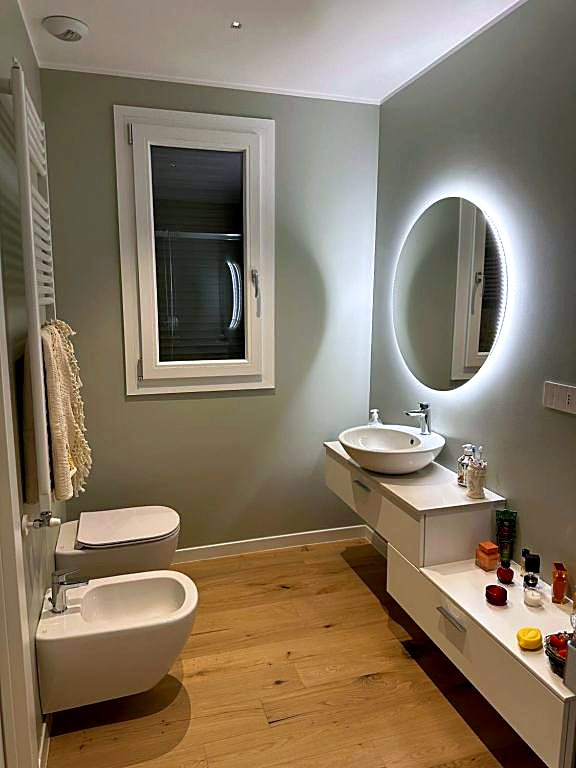 Bagno privato con specchio retroilluminato e lavabo in ceramica